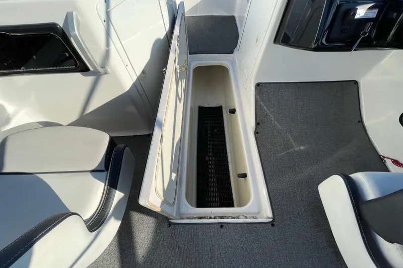 Slide: The Image of 2019 Yamaha Boats SX195 interior with seating and steering wheel, parked on pavement. - 19