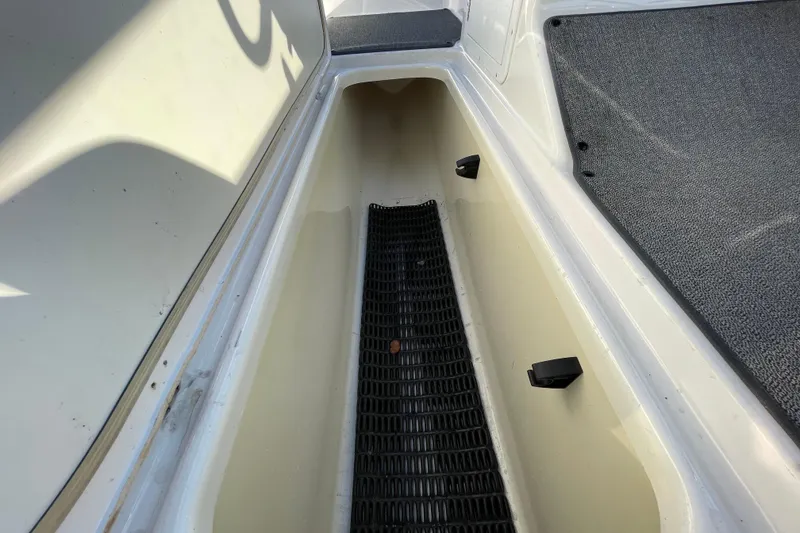 Slide: The Image of 2019 Yamaha Boats SX195 interior with seating, steering wheel, and canopy in a marina setting. - 20