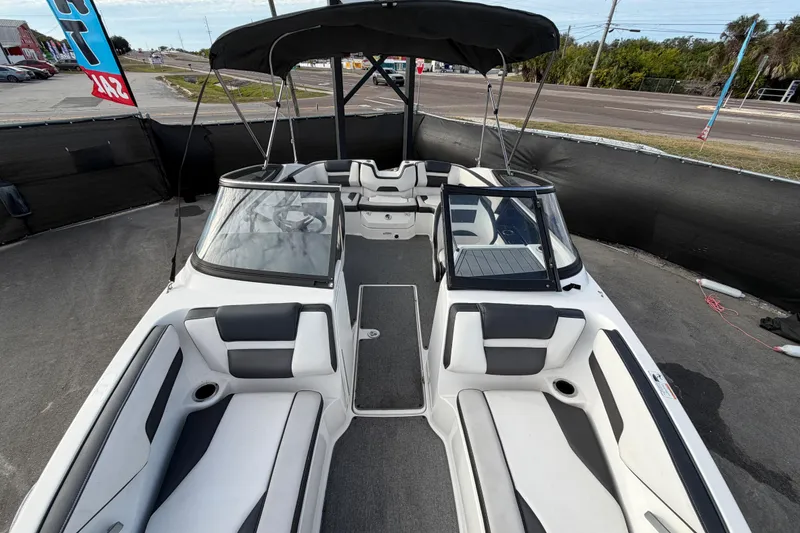 Slide: The Image of 2019 Yamaha Boats SX195 interior with seating and canopy, displayed outdoors. - 56