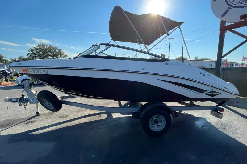Slide: The Image of 2019 Yamaha Boats SX195 with canopy, displayed for sale under a cloudy sky. - 6