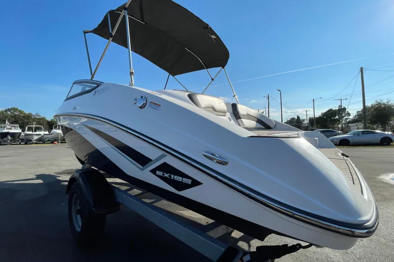 Slide: The Image of 2019 Yamaha Boats SX195 on trailer under cloudy sky. - 7