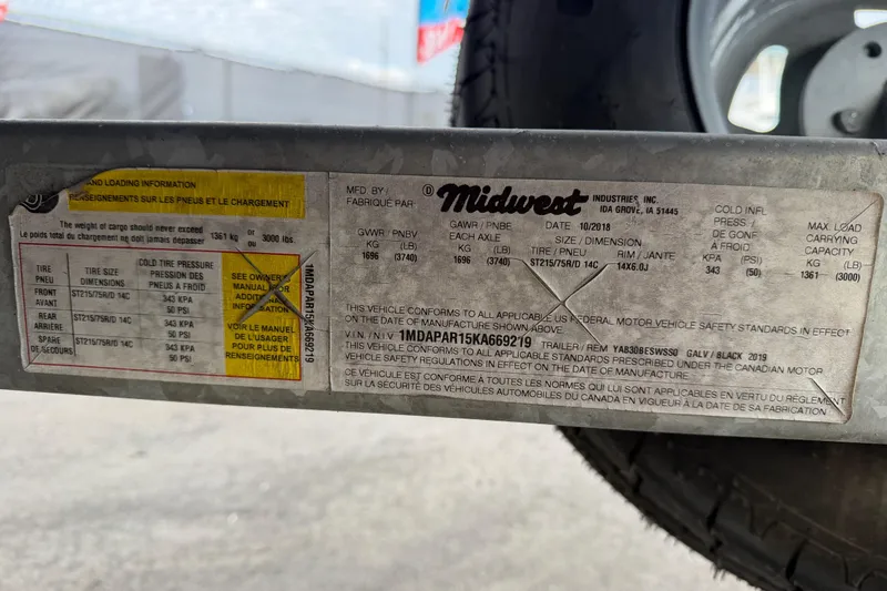 Slide: The Image of Close-up of a 2019 Yamaha Boats SX195 trailer wheel on pavement. - 78