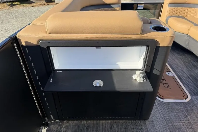 Slide: The Image of 2026 Godfrey Monaco 235 SFLC iMPACT boat interior with storage compartment and tan seating. - 15