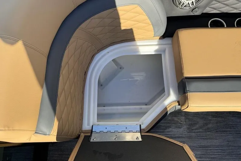 Slide: The Image of 2026 Godfrey Monaco 235 SFLC iMPACT boat seat storage compartment, tan and gray upholstery. - 2