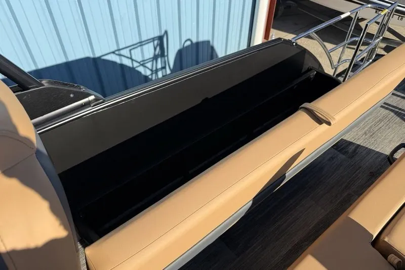 Slide: The Image of 2026 Godfrey Monaco 235 SFLC iMPACT boat with open storage compartment and tan seating. - 26