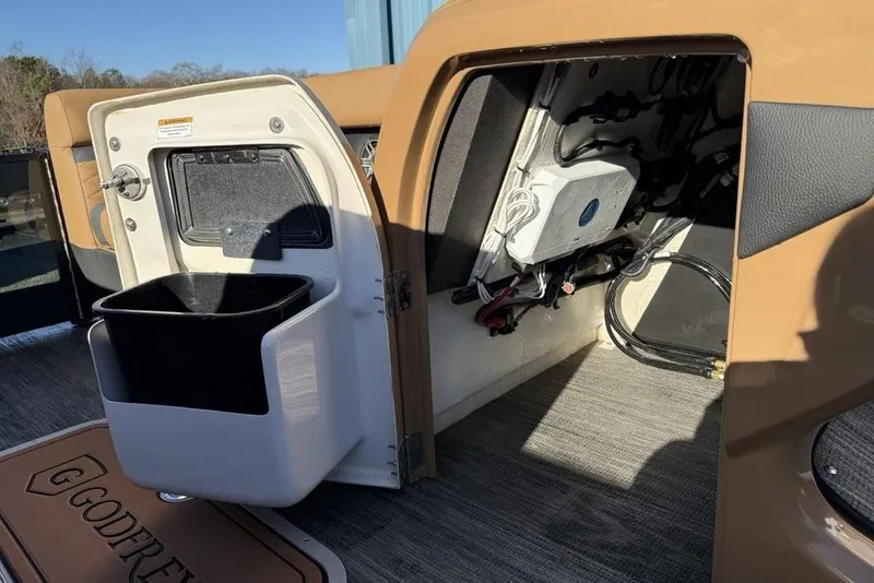 Slide: The Image of 2026 Godfrey Monaco 235 SFLC iMPACT boat interior storage compartment with wiring and trash bin. - 6