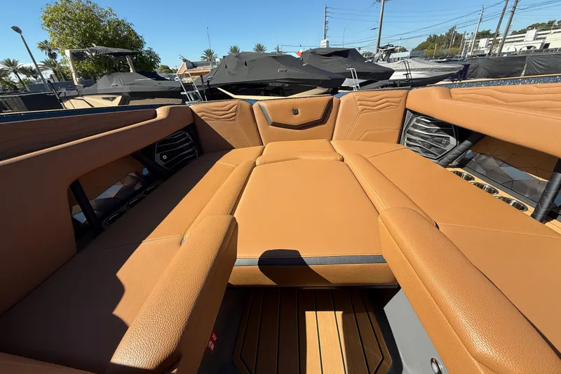 Slide: The Image of 2026 Nautique Super Air Nautique G25 Coastal Edition interior with tan seating and cup holders. - 11