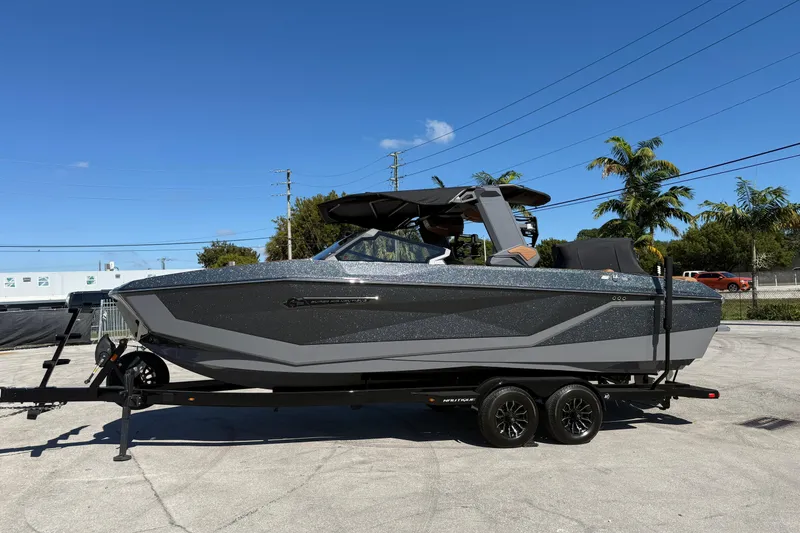 Slide: The Image of 2026 Nautique Super Air Nautique G25 Coastal Edition boat on trailer, sunny day. - 3