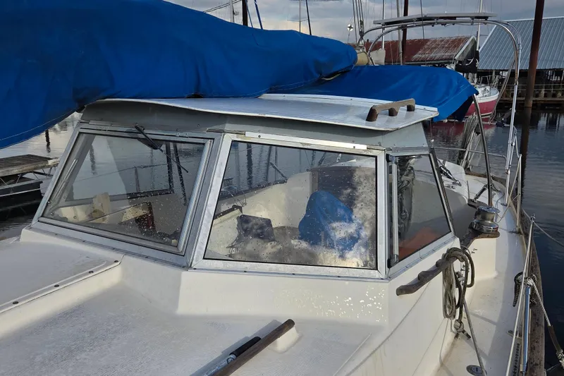 Slide: The Image of 1974 Hallberg-Rassy Rasmus 35 sailboat with blue cover docked at marina. - 2