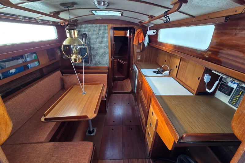 Slide: The Image of Interior of 1974 Hallberg-Rassy Rasmus 35 sailboat with wood finish and cozy seating area. - 6