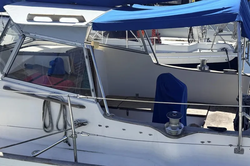 Slide: The Image of 1974 Hallberg-Rassy Rasmus 35 sailboat cockpit with blue canopy and winch. - 79