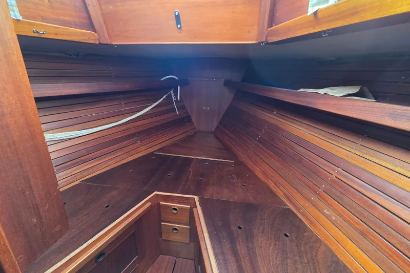 Slide: The Image of Interior of 1974 Hallberg-Rassy Rasmus 35 sailboat, featuring wooden paneling and storage compartments. - 8