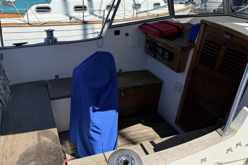 Slide: The Image of Cockpit of a 1974 Hallberg-Rassy Rasmus 35 sailboat with covered equipment. - 82