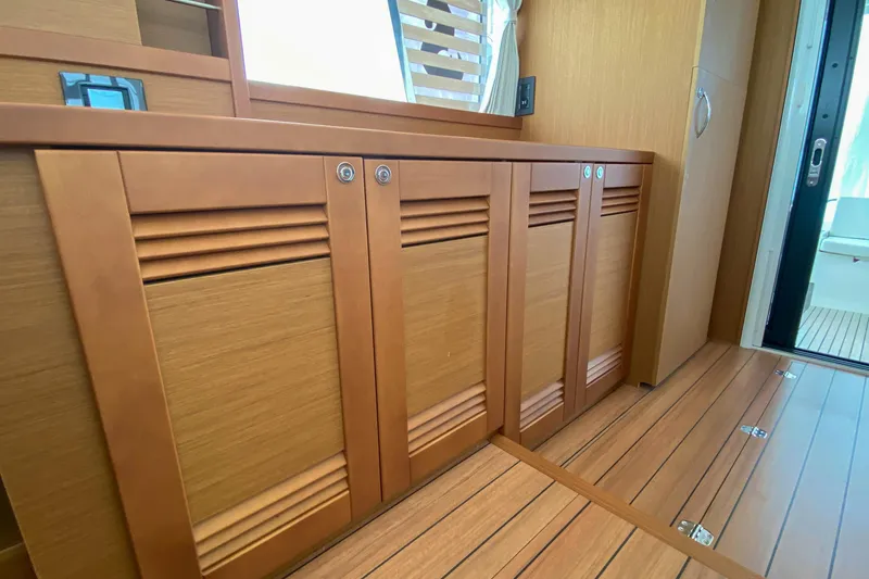 Slide: The Image of Interior view of 2023 Beneteau Swift Trawler 41 Fly, featuring wooden cabinetry and flooring. - 10