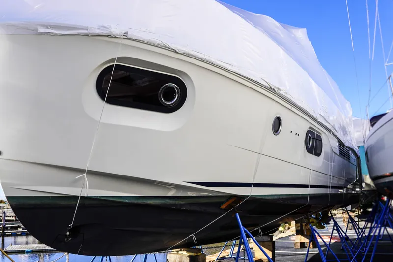 Slide: The Image of 2023 Beneteau Swift Trawler 41 Fly yacht in dry dock, partially covered. - 35