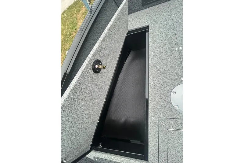 Slide: The Image of 2026 Lund 1700 Explorer Sport boat storage compartment, open lid, gray interior. - 16