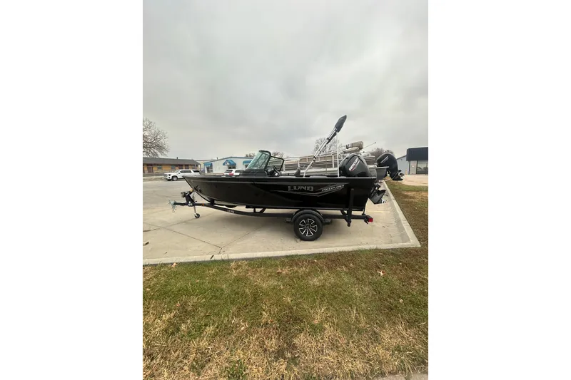 Slide: The Image of 2026 Lund 1700 Explorer Sport boat on trailer in parking lot. - 2