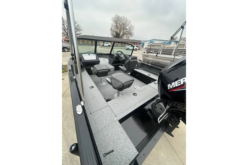 Slide: The Image of 2026 Lund 1700 Explorer Sport boat interior with Mercury engine, featuring modern seating and controls. - 34