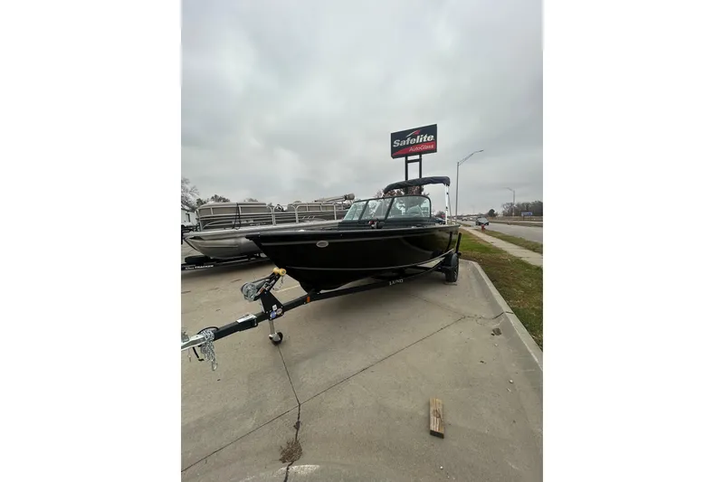 Slide: The Image of 2026 Lund 1700 Explorer Sport boat on trailer, parked near Safelite AutoGlass sign. - 8