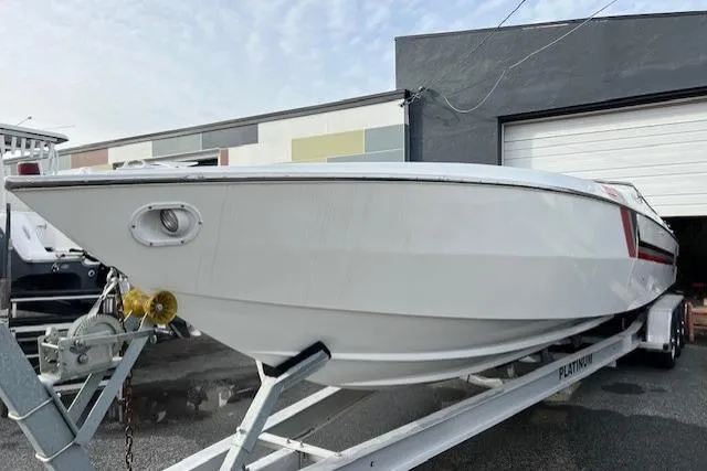 The Image of 1989 Cigarette Cafe Racer 35 speedboat on trailer, white with red and black stripes. - 0