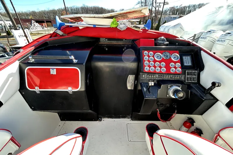 Slide: The Image of 1989 Cigarette Cafe Racer 35 boat dashboard with red accents and multiple gauges. - 11