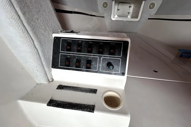 Slide: The Image of Control panel inside 1989 Cigarette Cafe Racer 35 boat, featuring switches and a cup holder. - 14