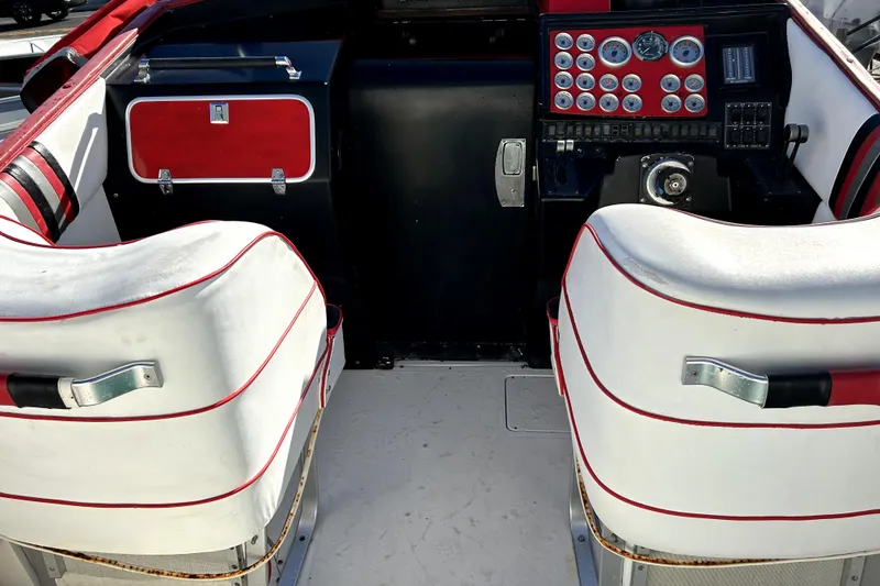 Slide: The Image of 1989 Cigarette Cafe Racer 35 boat interior with white and red seating, dashboard controls. - 17