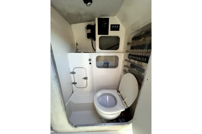 Slide: The Image of 1989 Cigarette Cafe Racer 35 boat interior with compact bathroom and control panel. - 18