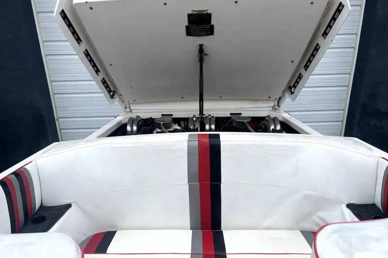 Slide: The Image of 1989 Cigarette Cafe Racer 35 boat engine compartment with open hatch and striped seating. - 20