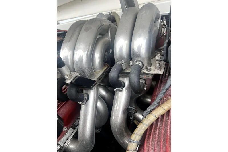 Slide: The Image of Engine components of a 1989 Cigarette Cafe Racer 35 boat, featuring metallic pipes and hoses. - 21