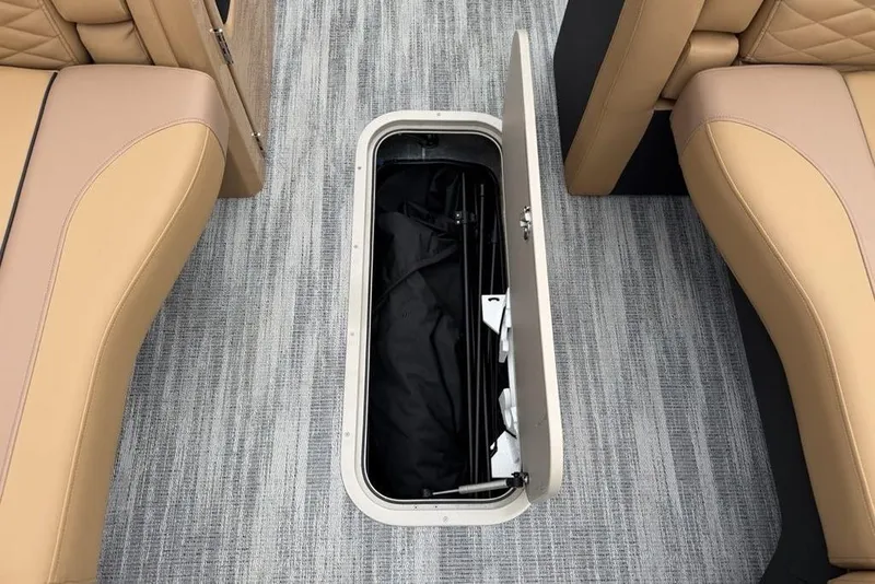 Slide: The Image of Open storage compartment on 2026 Godfrey Monaco 235 SFLC iMPACT boat, between tan seats. - 15