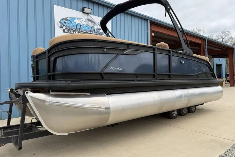 Slide: The Image of 2026 Godfrey Monaco 235 SFLC iMPACT pontoon boat on trailer at marina. - 3