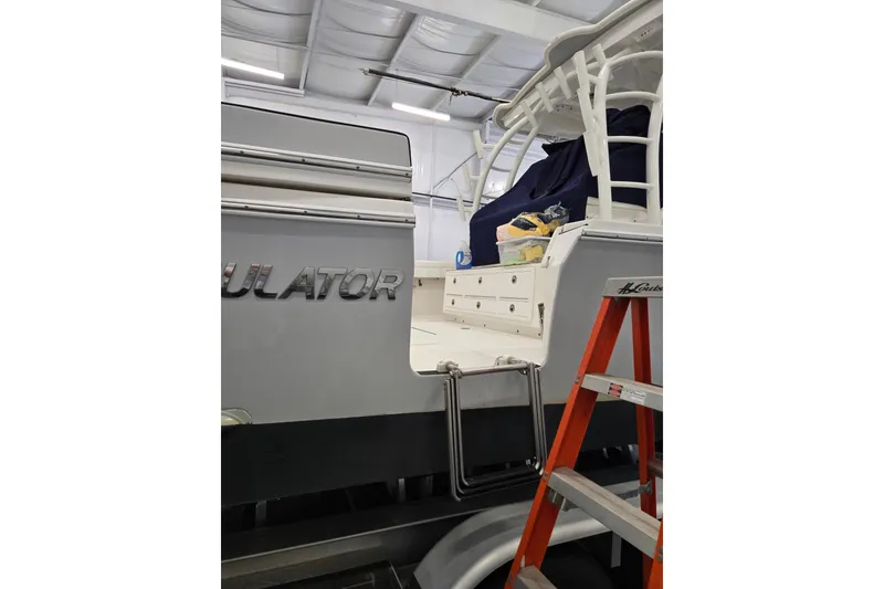 Slide: The Image of 2020 Regulator 41 boat in storage, featuring a ladder and covered deck. - 44