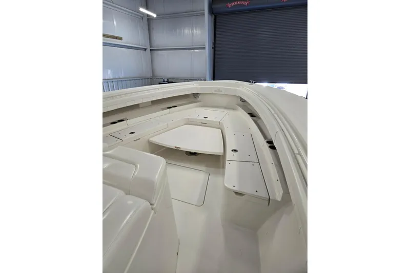 Slide: The Image of 2020 Regulator 41 boat interior with white seating and table in a storage facility. - 49