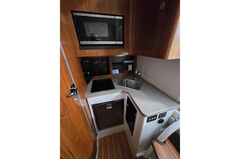 Slide: The Image of 2020 Regulator 41 boat interior with kitchenette, featuring microwave, sink, and compact design. - 52
