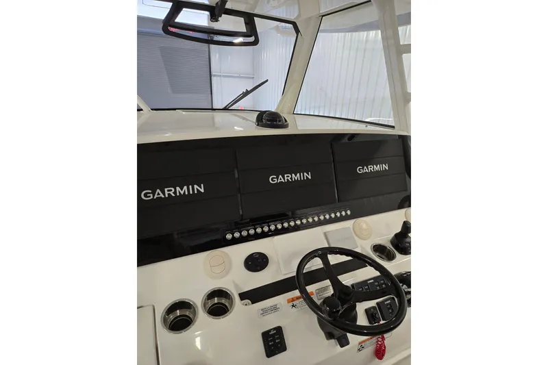 Slide: The Image of 2020 Regulator 41 boat dashboard with Garmin navigation displays and steering wheel. - 64