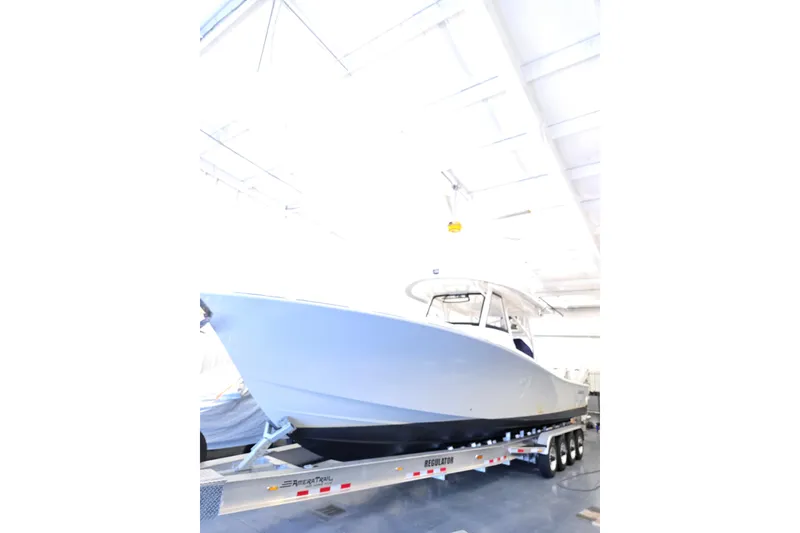 Slide: The Image of 2020 Regulator 41 boat on trailer in a bright indoor setting. - 68