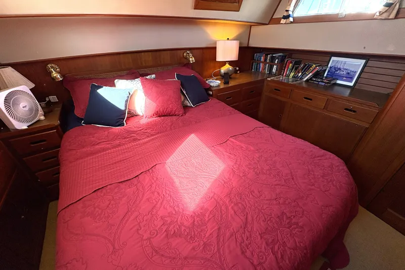 Slide: The Image of Cozy bedroom in 1993 Grand Banks 42 Classic yacht with red bedding and wooden cabinetry. - 18