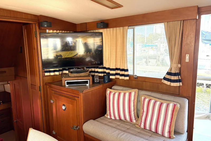 Slide: The Image of Interior of 1993 Grand Banks 42 Classic yacht with TV, striped cushions, and wood paneling. - 26