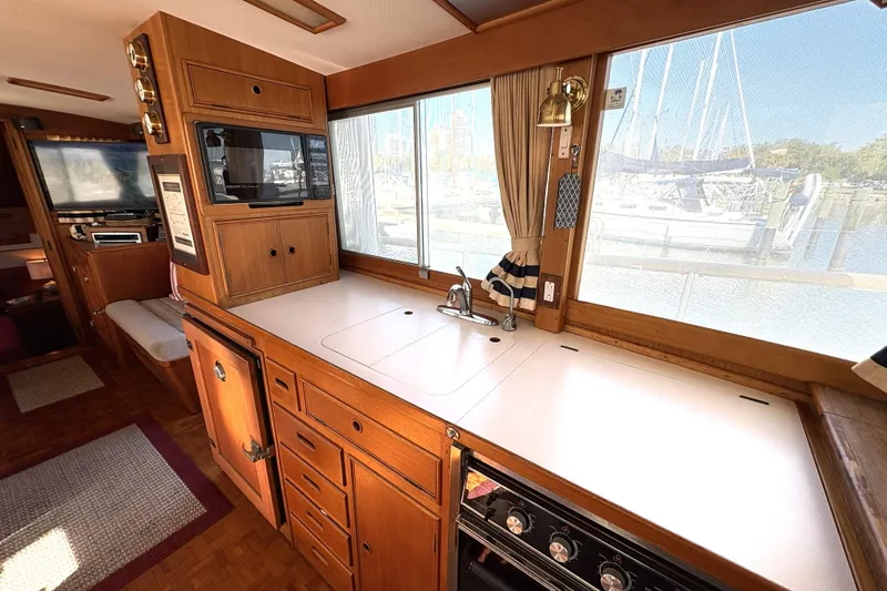 Slide: The Image of Interior of 1993 Grand Banks 42 Classic yacht kitchen with wood cabinetry and marina view. - 28