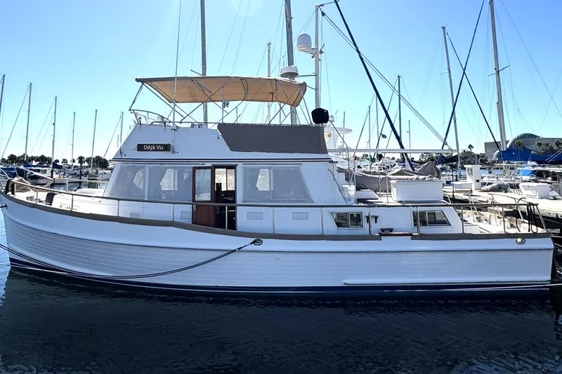 Slide: The Image of 1993 Grand Banks 42 Classic yacht docked in a marina, featuring a sleek design and spacious deck. - 4