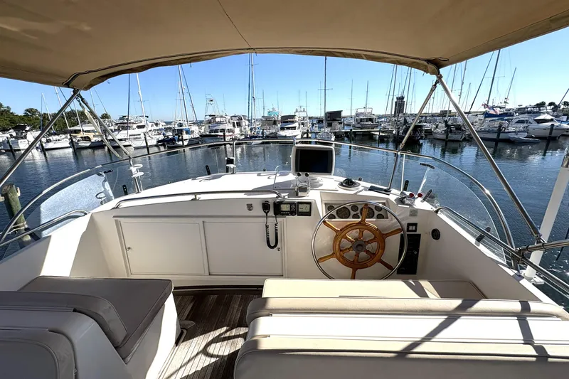 Slide: The Image of Helm of 1993 Grand Banks 42 Classic yacht in marina, showcasing steering wheel and controls. - 6