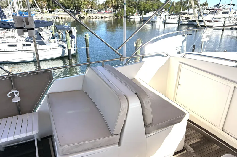 Slide: The Image of Flybridge seating on a 1993 Grand Banks 42 Classic yacht, overlooking a marina. - 8