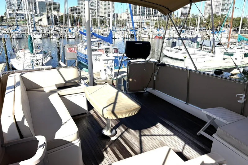Slide: The Image of 1993 Grand Banks 42 Classic yacht interior with marina view, featuring comfortable seating and a grill. - 9