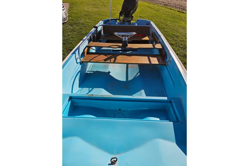Slide: The Image of 1972 Boston Whaler Sourpuss 13 boat interior with blue hull and wooden seating. - 3