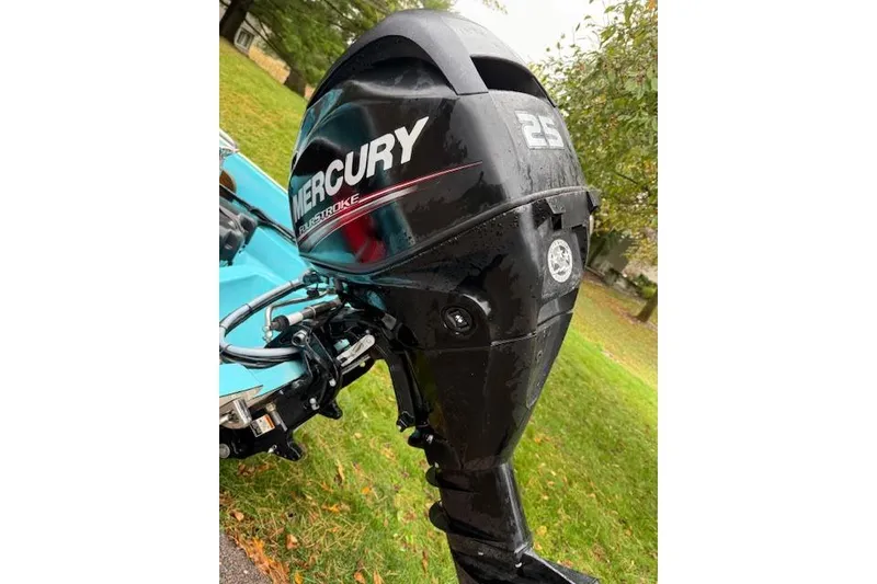 Slide: The Image of 1972 Boston Whaler Sourpuss 13 with Mercury 25 outboard motor, parked on grass. - 5