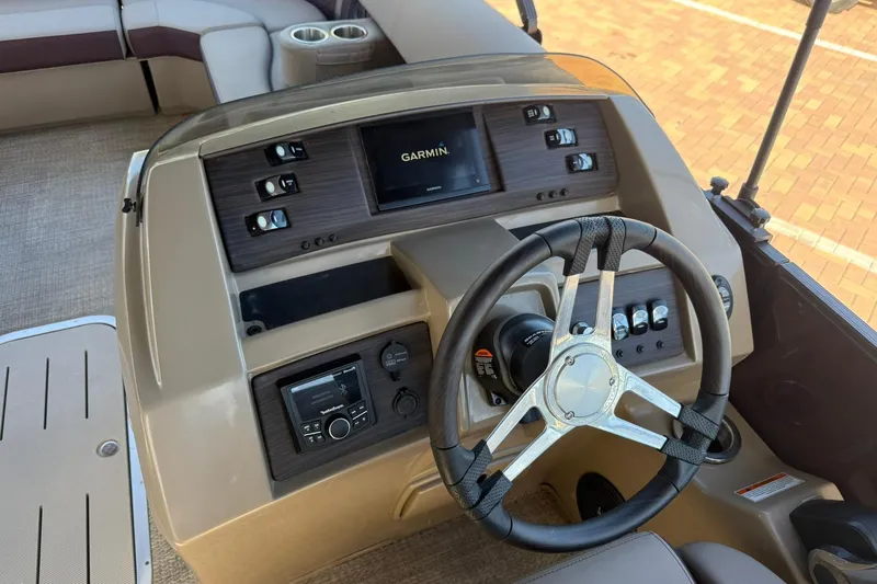 Slide: The Image of 2025 Bennington 23 LPD boat dashboard with Garmin navigation system and steering wheel. - 23