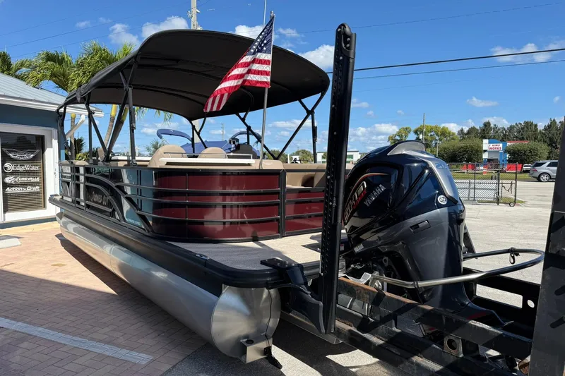 Slide: The Image of 2025 Bennington 23 LPD pontoon boat with Yamaha engine and American flag. - 4