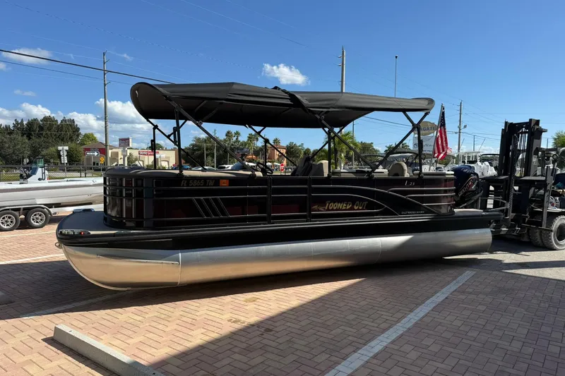 Slide: The Image of 2025 Bennington 23 LPD pontoon boat with canopy on a trailer in a parking lot. - 5