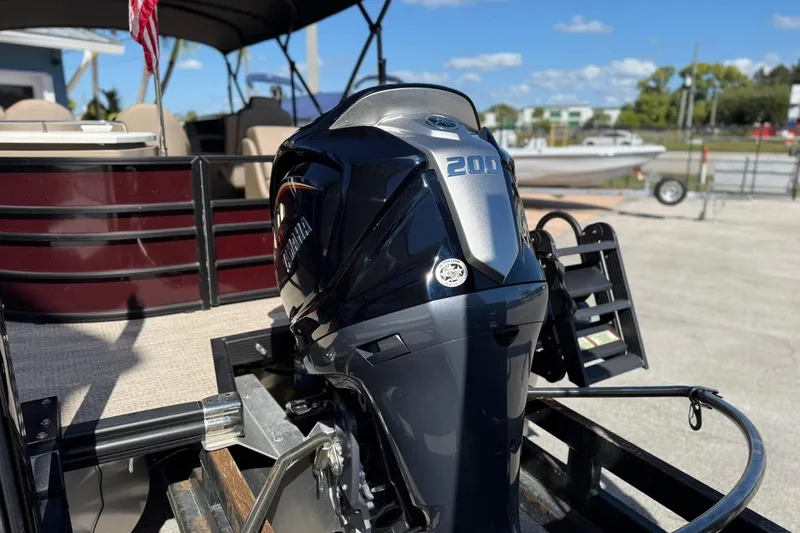 Slide: The Image of 2025 Bennington 23 LPD boat with Yamaha 200 outboard motor, parked outdoors. - 8